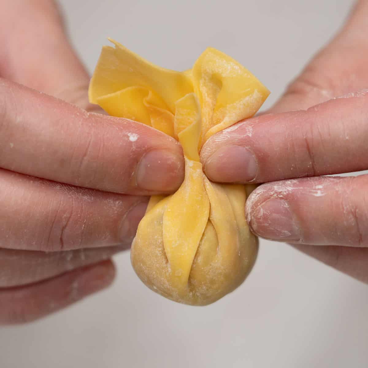 Forming the wonton wrapper into a simple pouch.