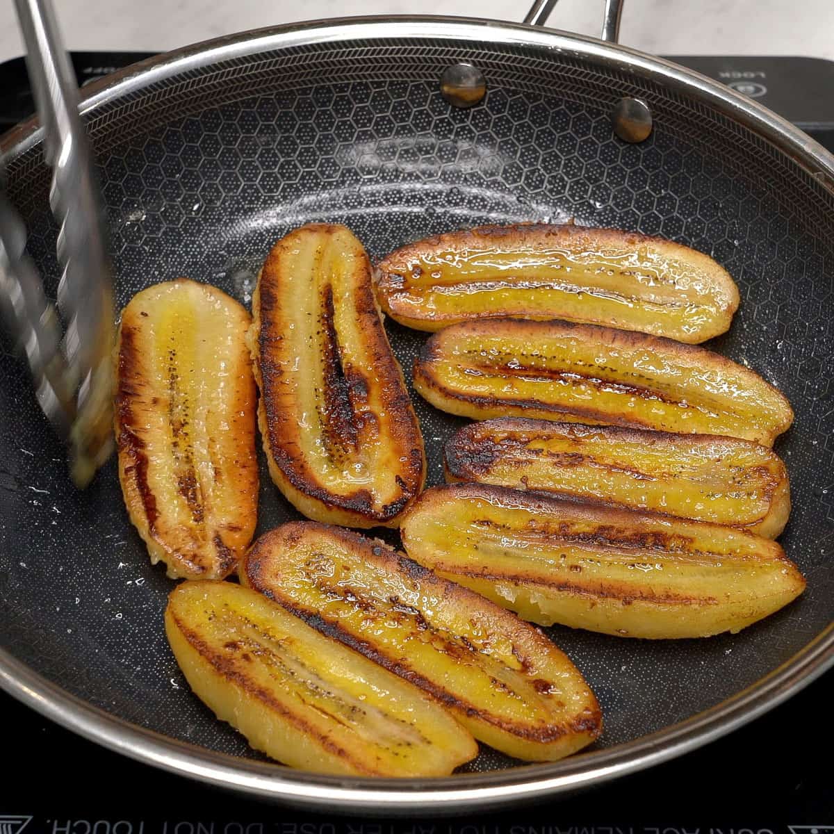 Frying the bananas in a pan.