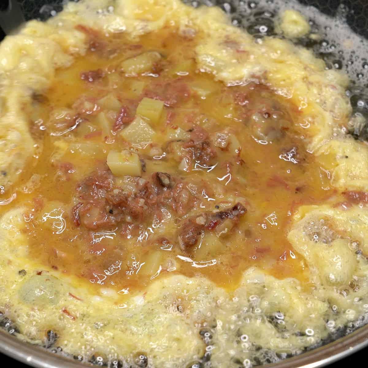 Frying tortang corned beef in a pan.