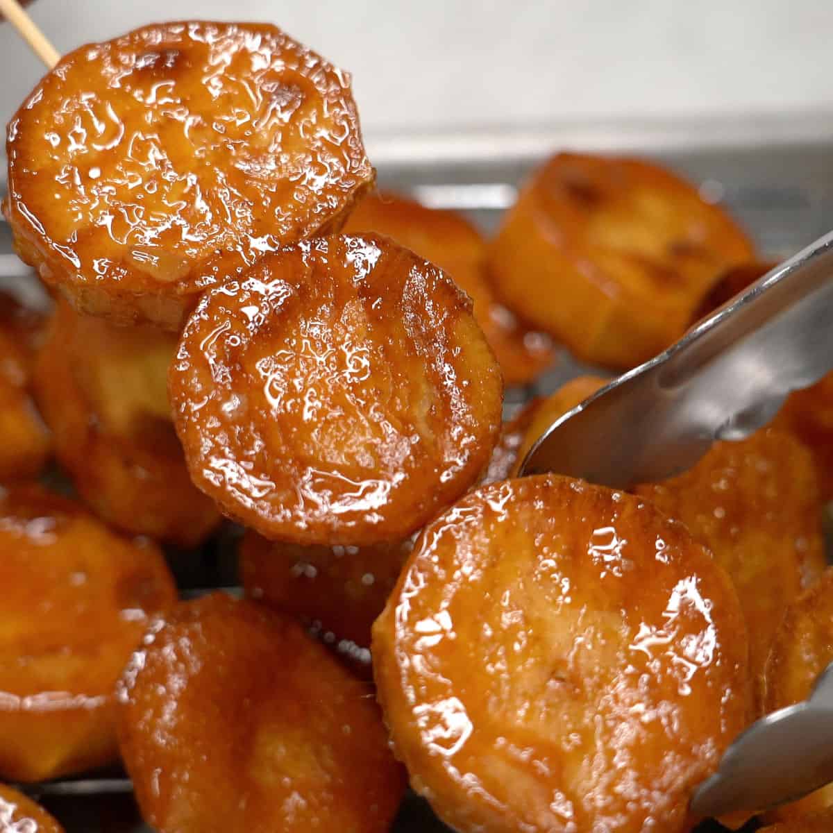 Skewering the caramelized sweet potatoes.