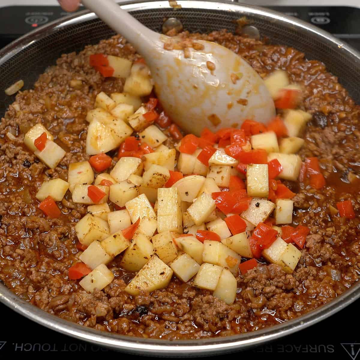 Ground meat and vegetables in a pan.