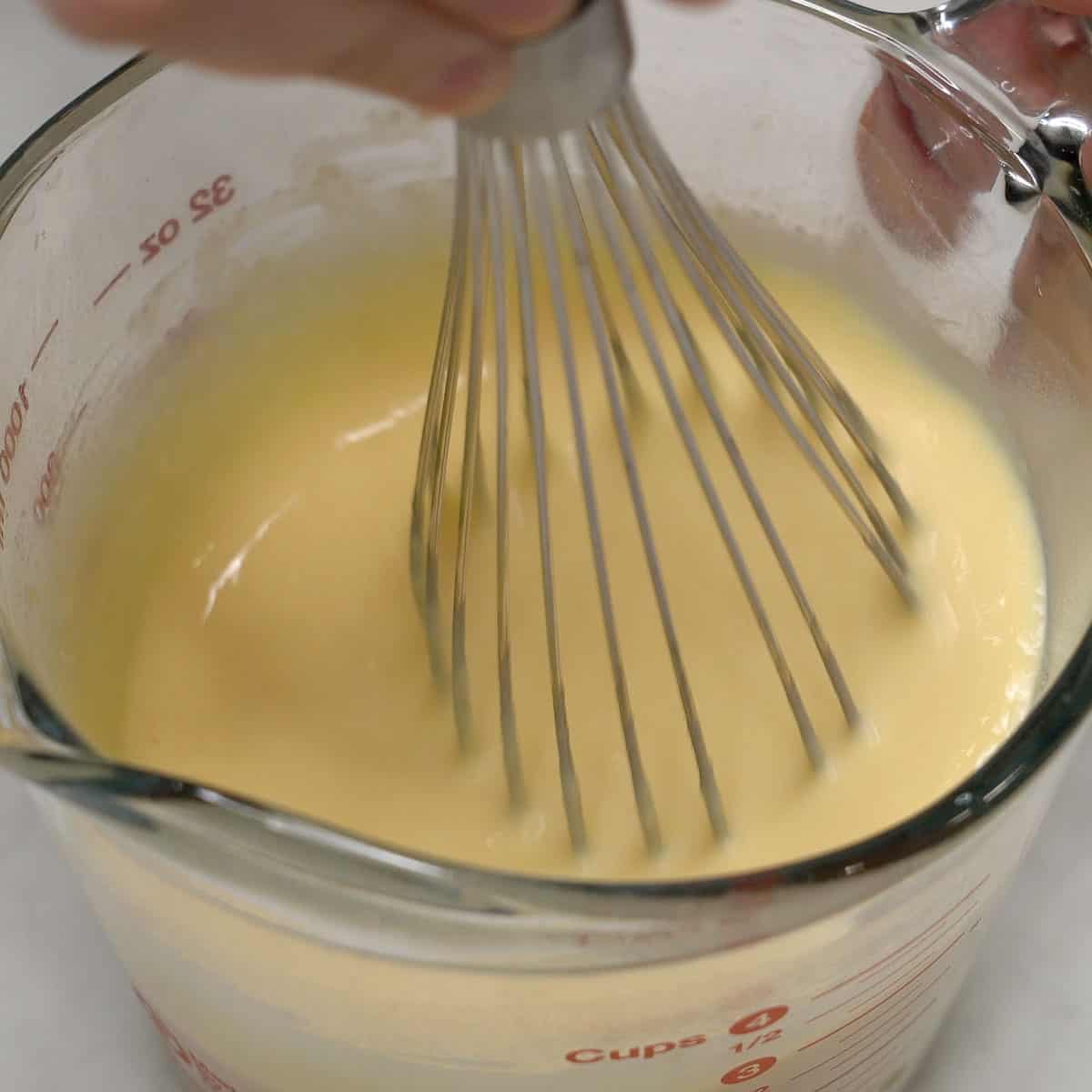Whisking the pudding mixture in a cup.