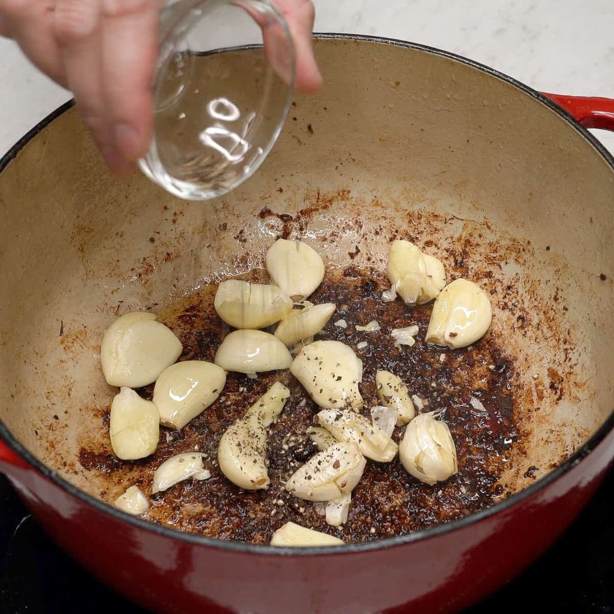 Sauteing garlic and peppercorns in a pot.