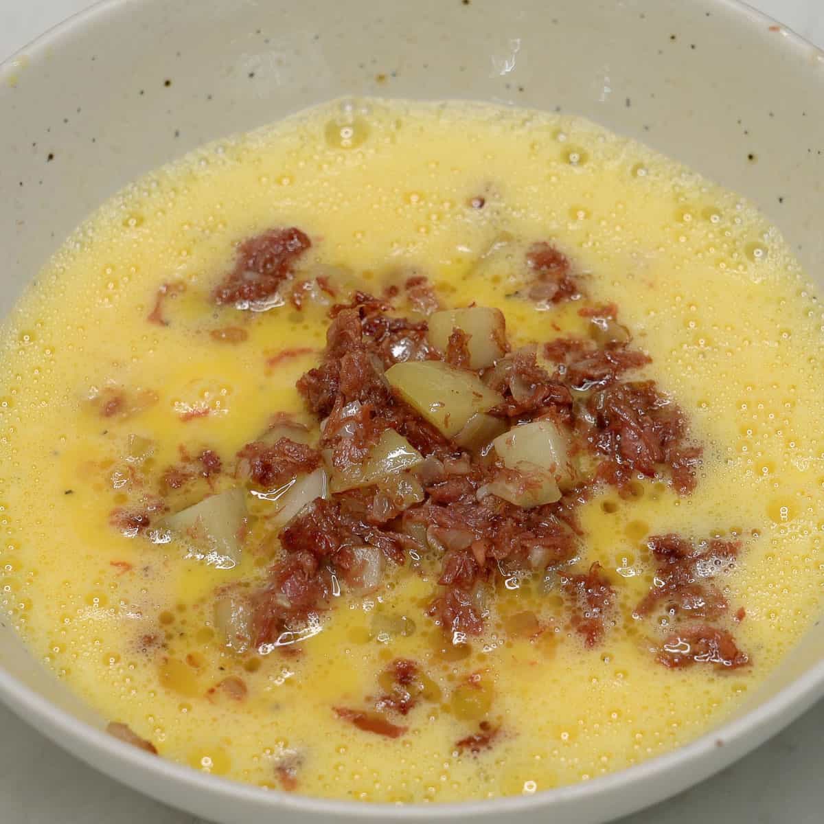 Scrambled eggs and corned beef in a bowl.