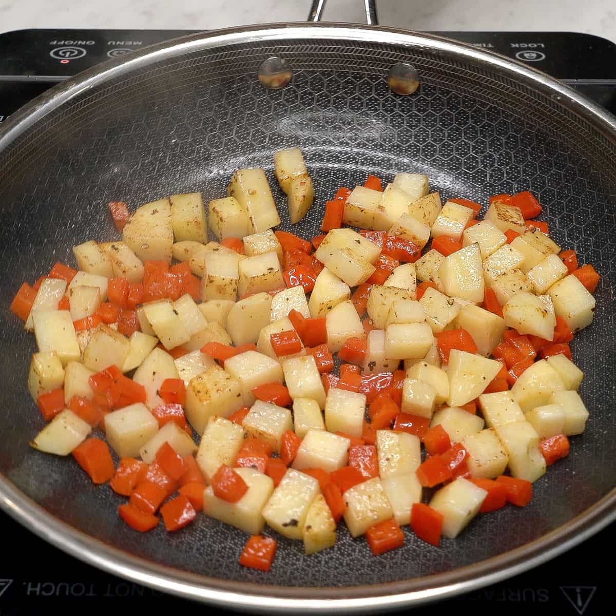 Searing the vegetables in a pan.