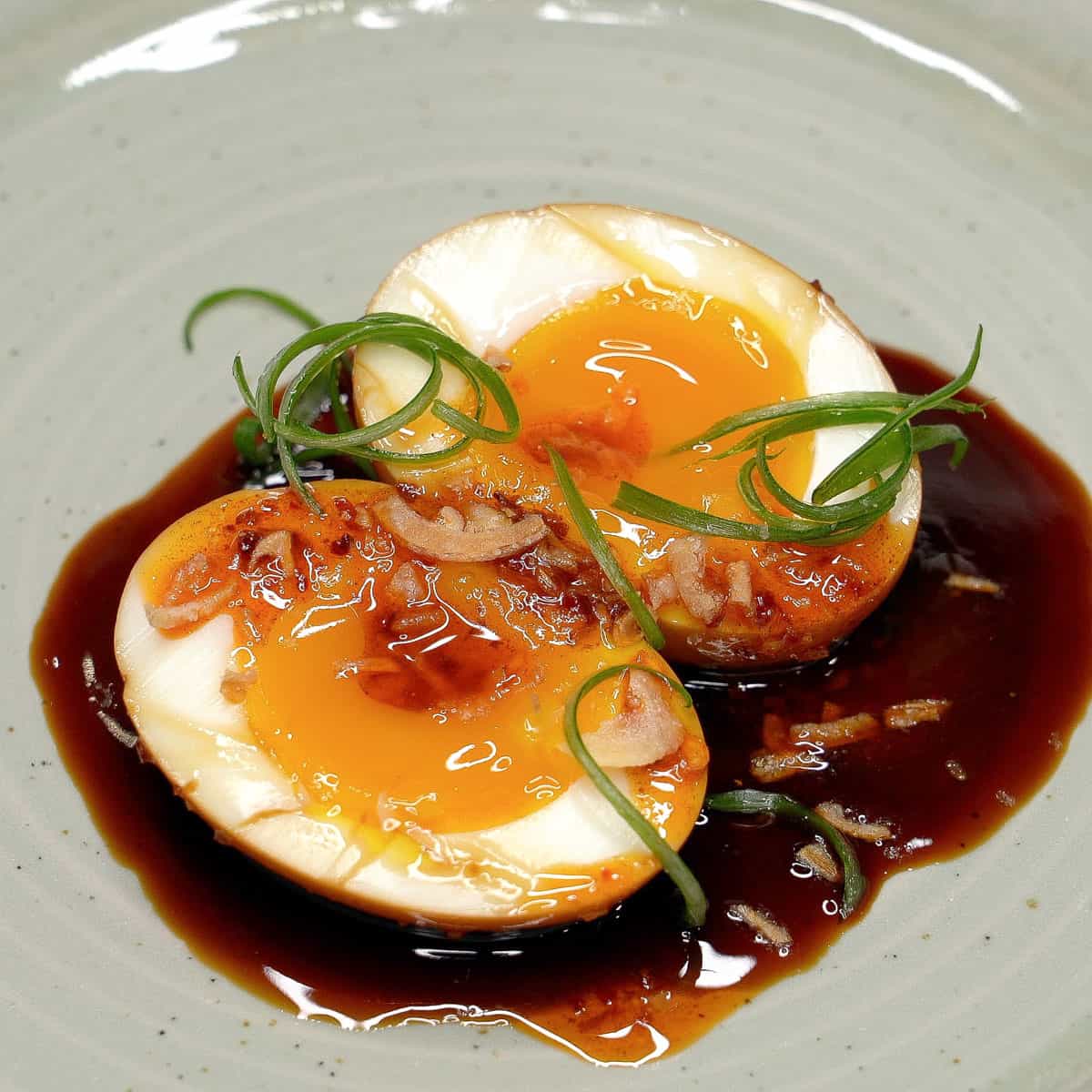 Adobong itlog with chili garlic oil, fried shallots, and scallions.