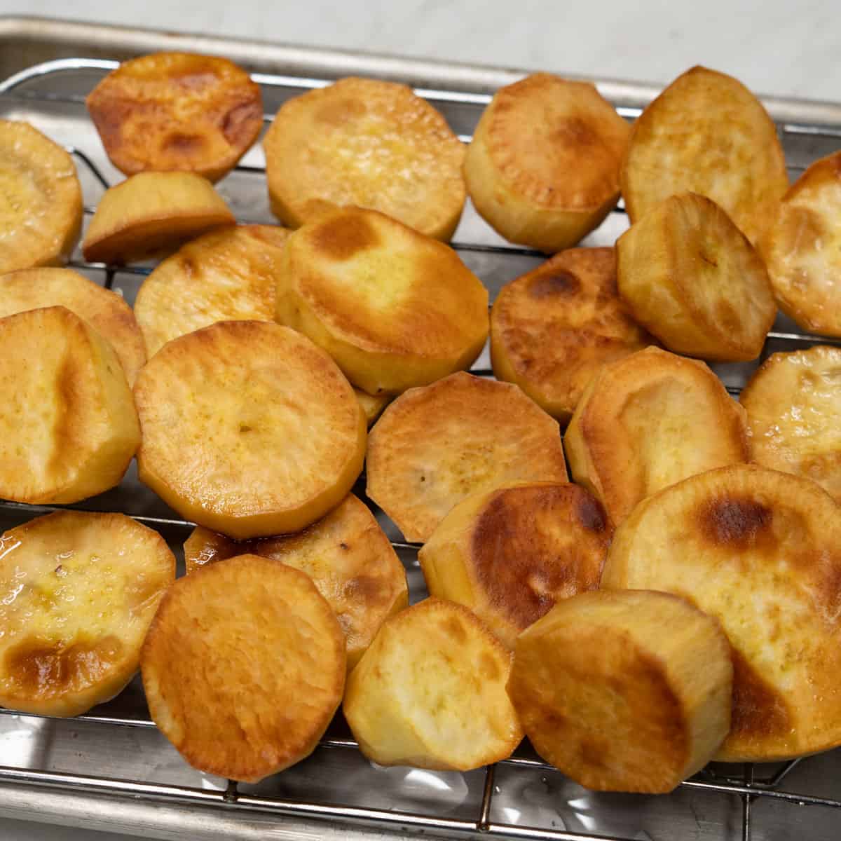 Fried sweet potatoes on a wire rack.