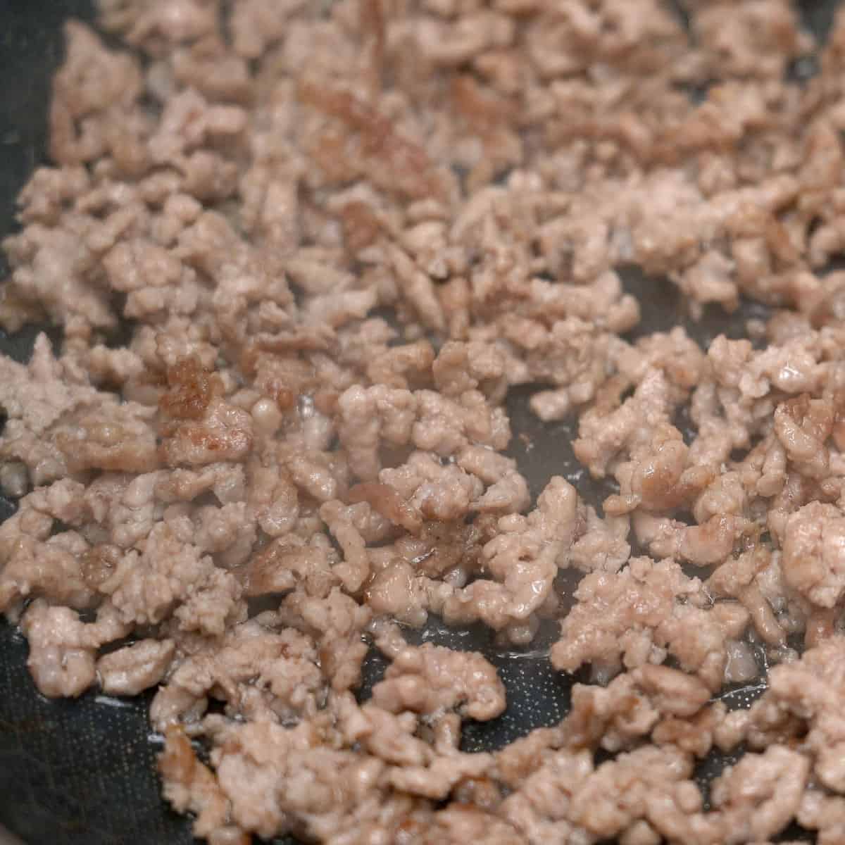 Browning the ground pork in the pan.