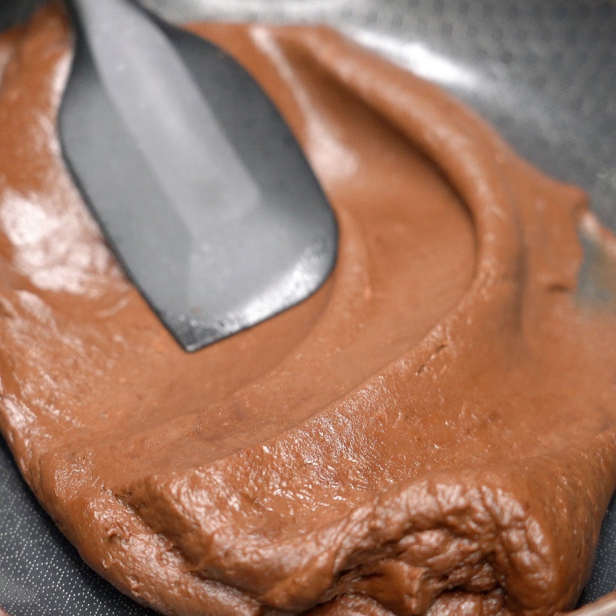 Mixing smooth chocolate mixture using a spatula.