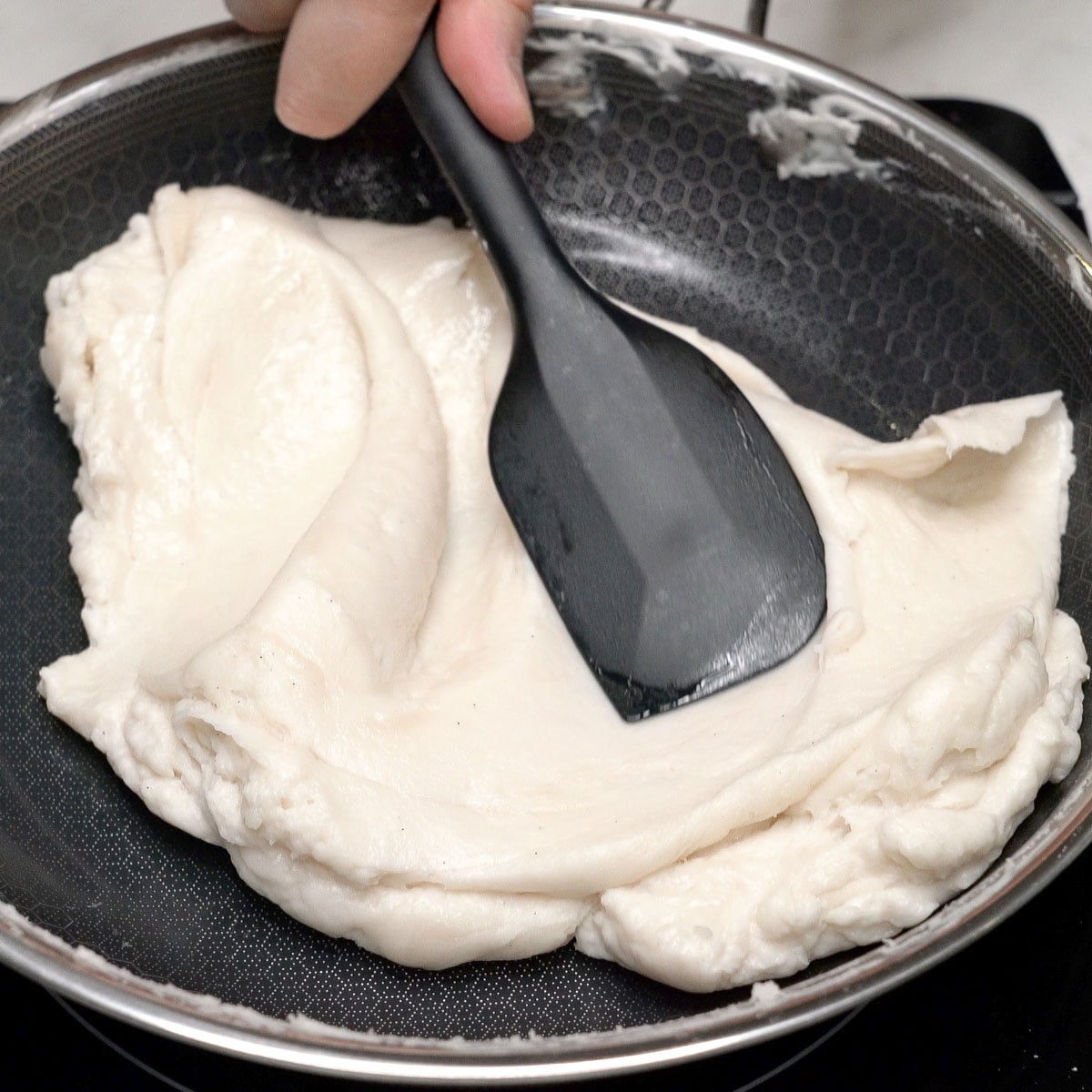 Mixing smooth plain mixture using a spatula.