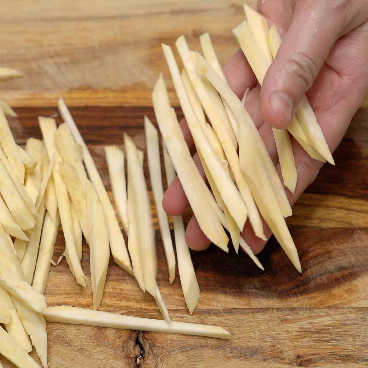 Cutting the sweet potatoes into thin strips.