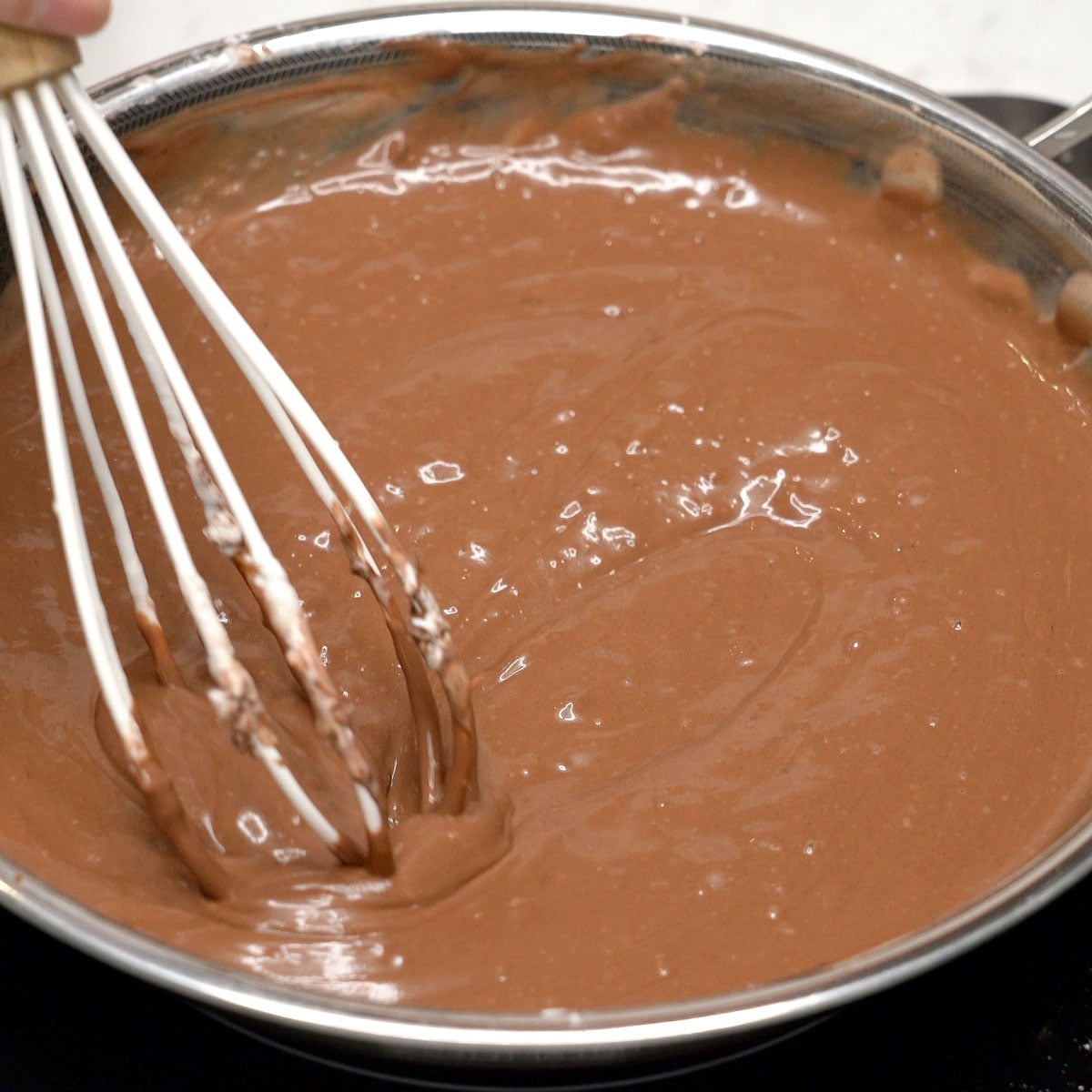 Whisking chocolate mixture in a pan.