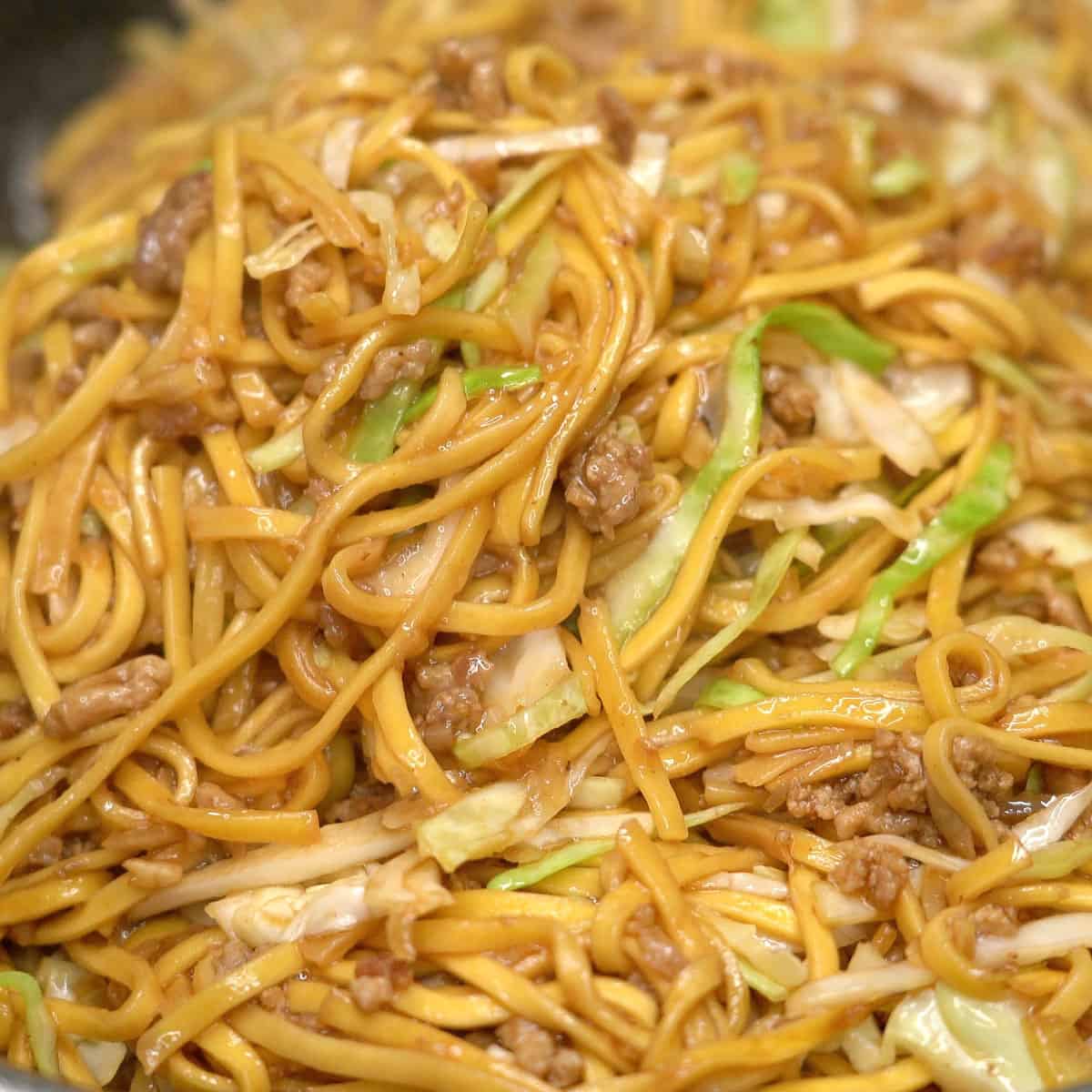 Cooked pancit canton with ground pork and cabbage in a wok.
