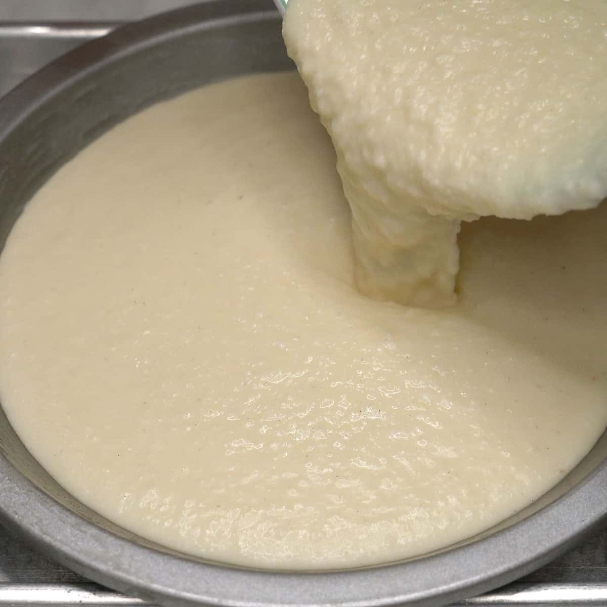 Pouring the cassava cake (budin) mxture into the pie pan.