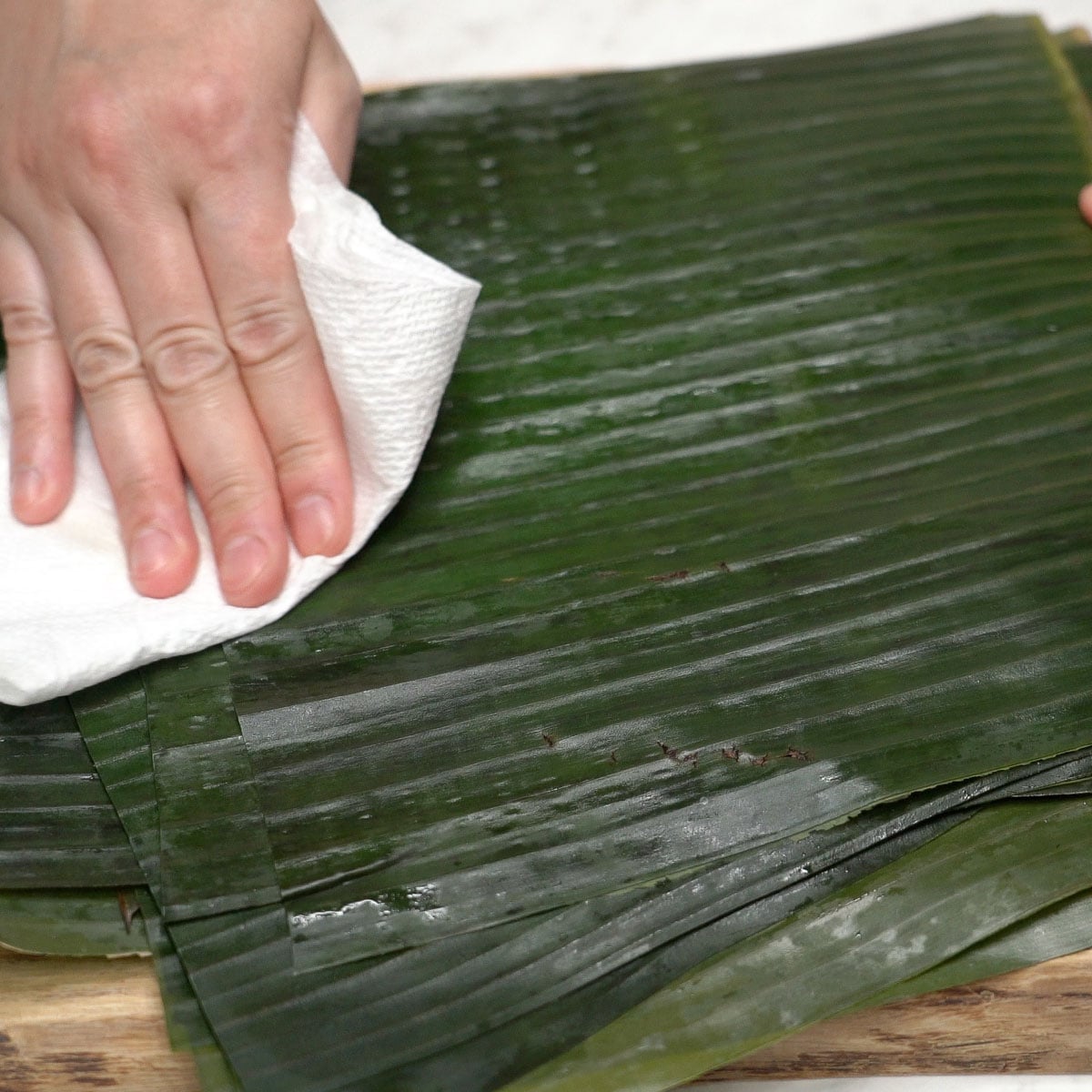 Wiping banana leaves.