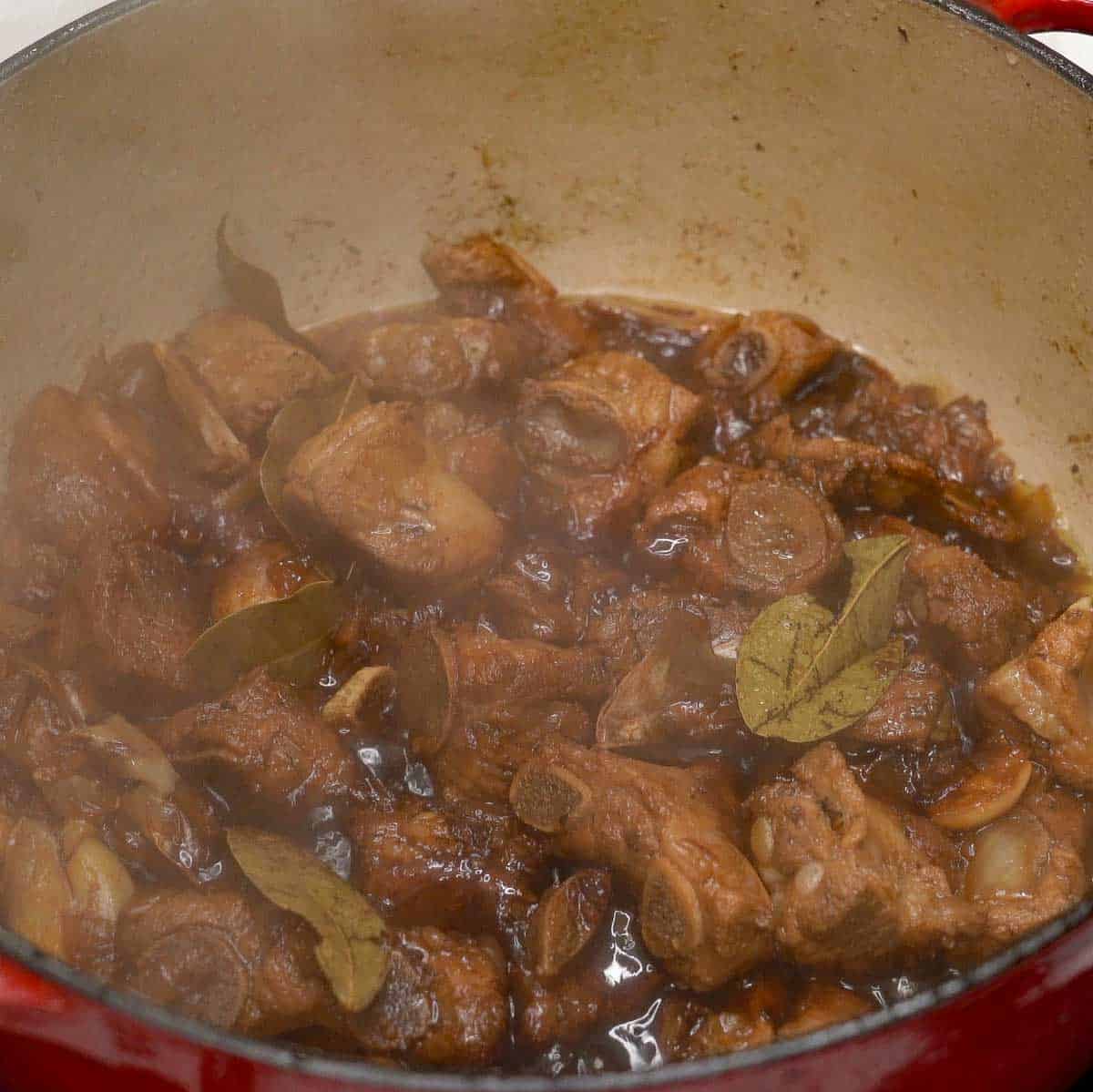Reducing pork ribs adobo sauce.