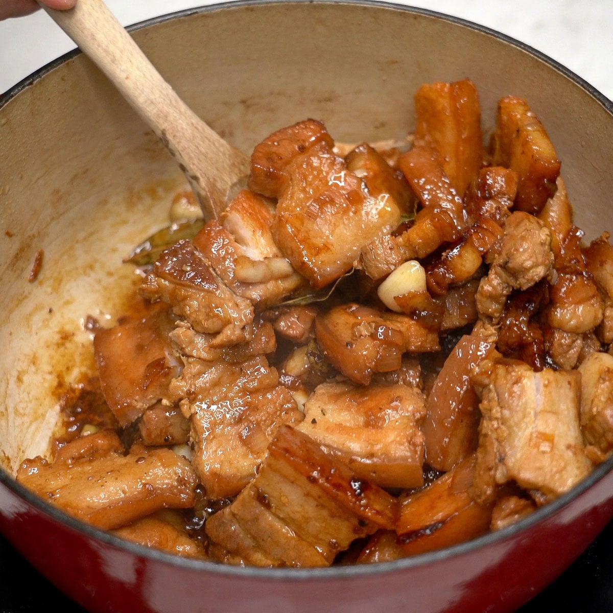 Mixing adobong tuyo in a pot.