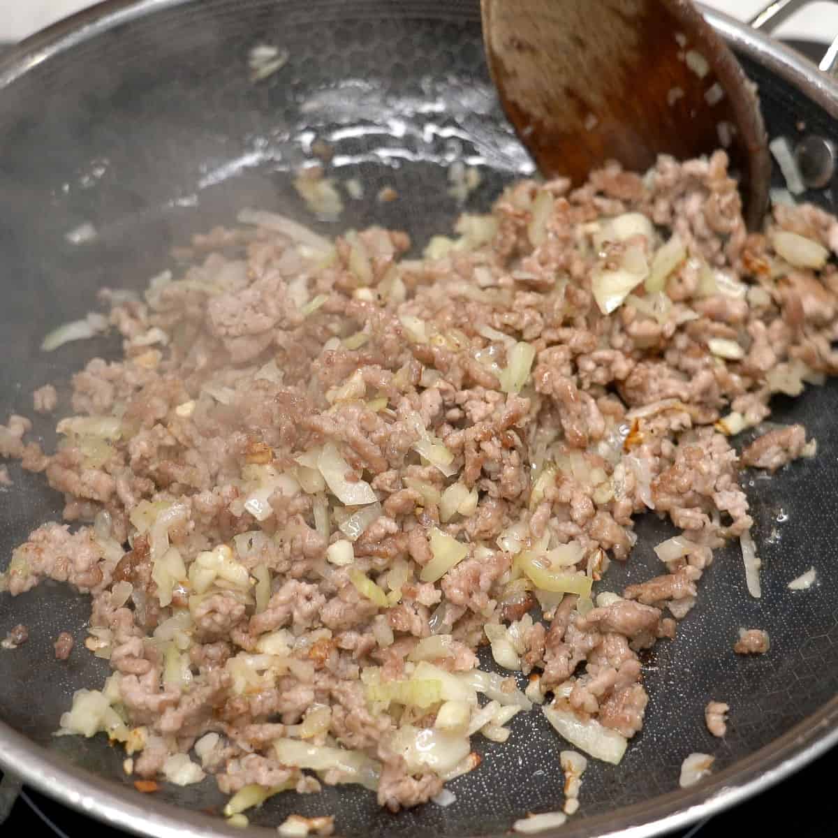 Sauteing the aromatics with the ground pork.