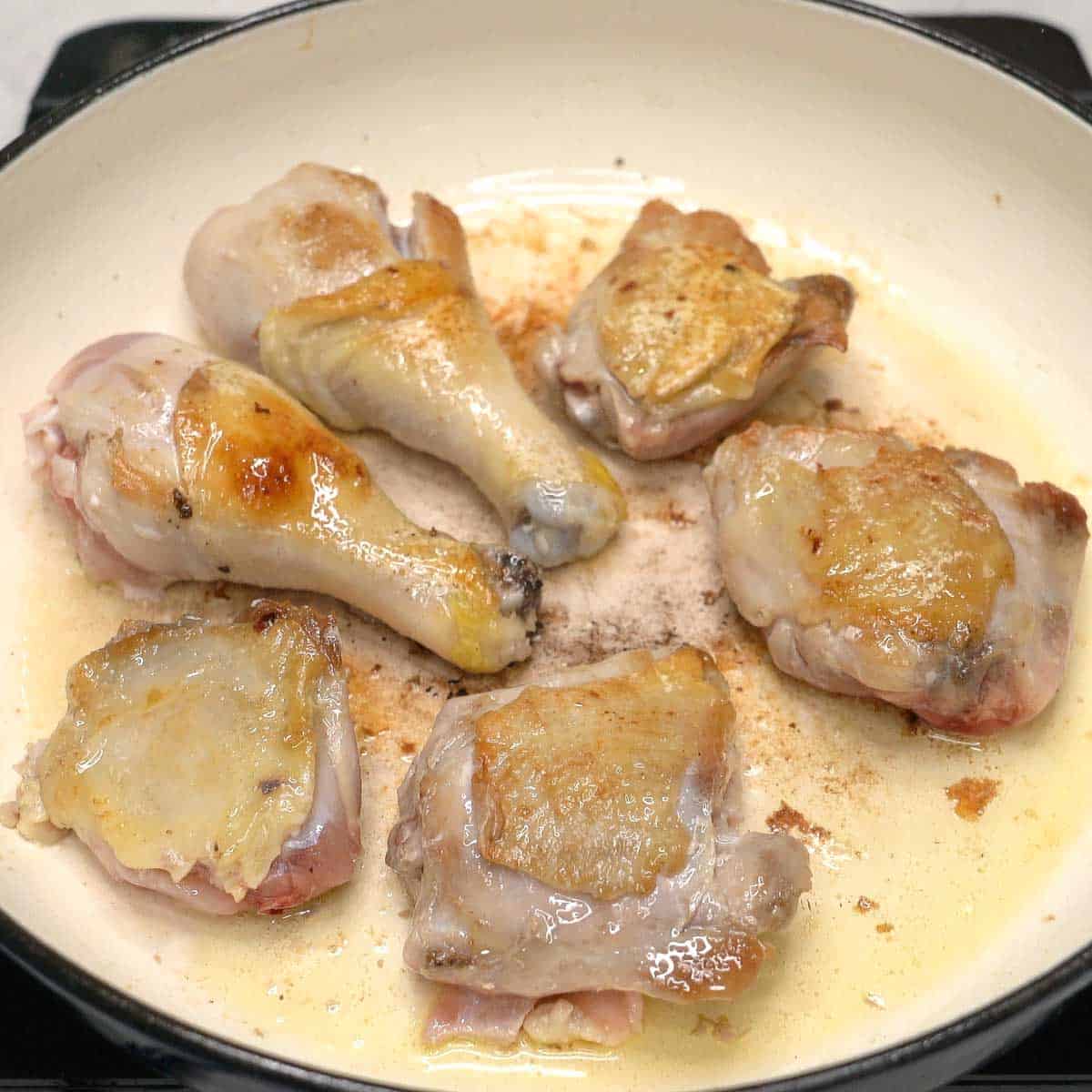 Searing chicken in a pan.