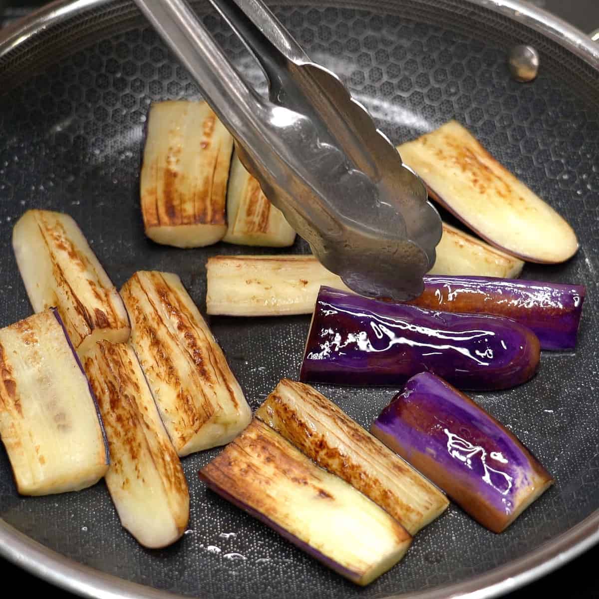 Searing the eggplant in a pan.