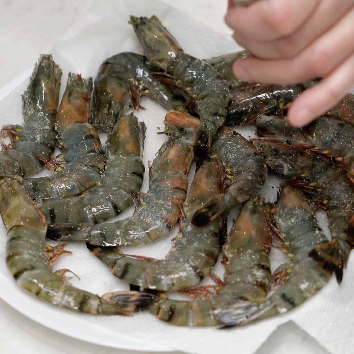 Seasoning shrimp with salt.