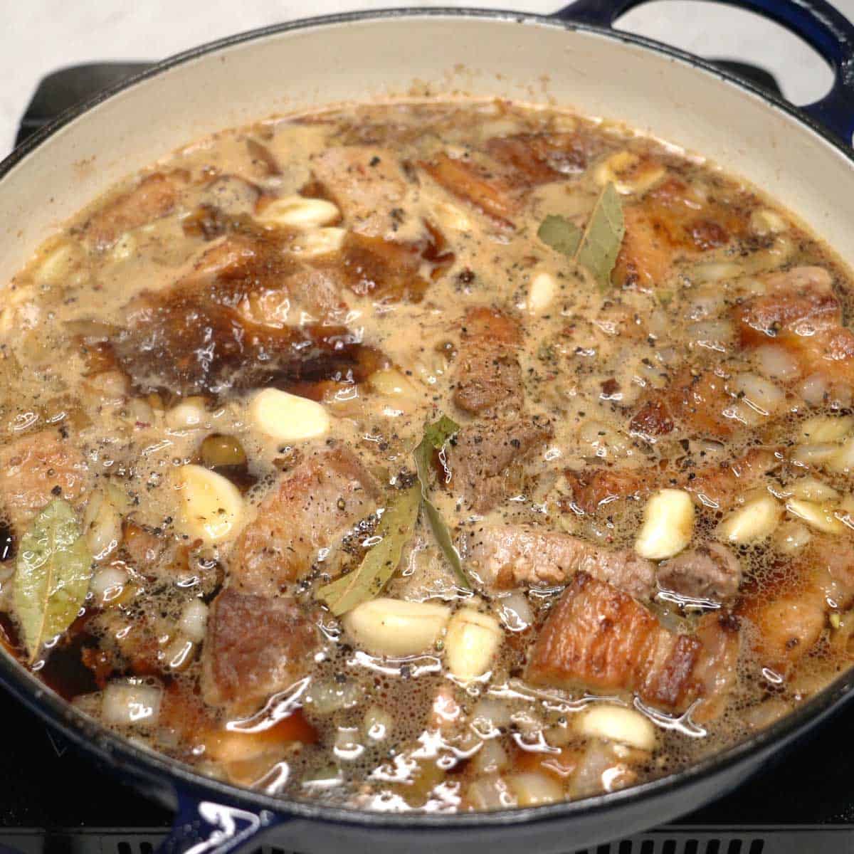 Simmering pork in a pan.