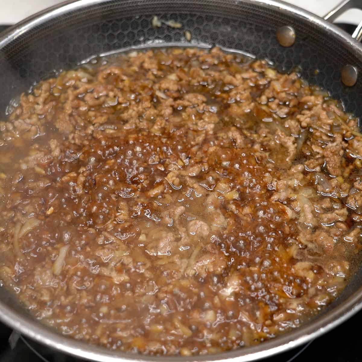 Simmering adobong talong with giniling in a pan.