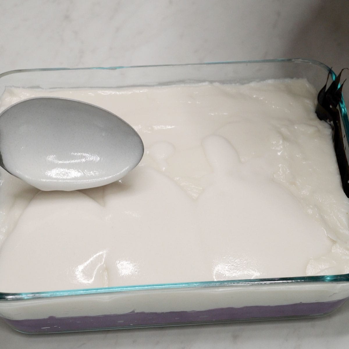 Spreading the coconut cream on top of the white layer.