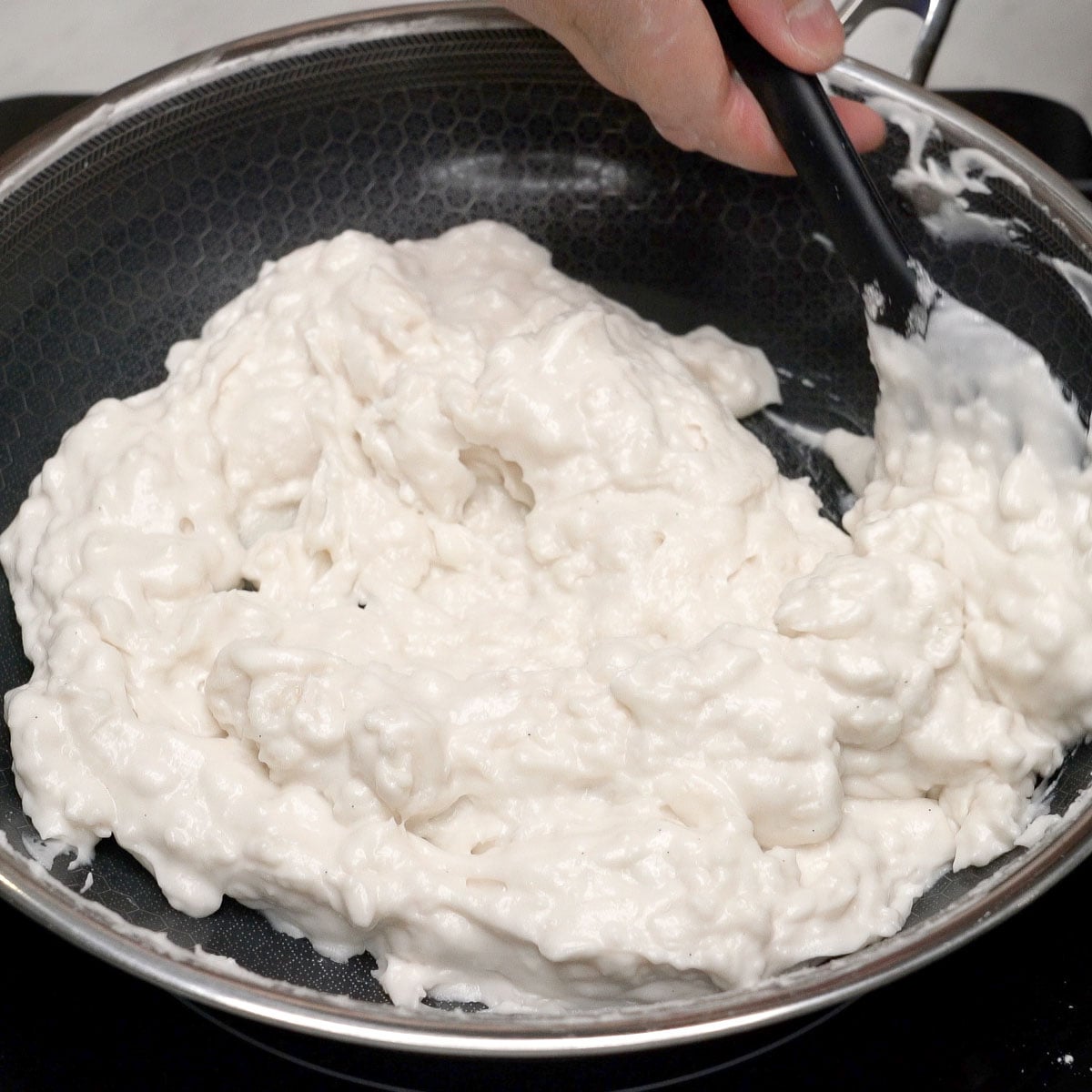 Mixing lumpy plain mixture using a spatula.