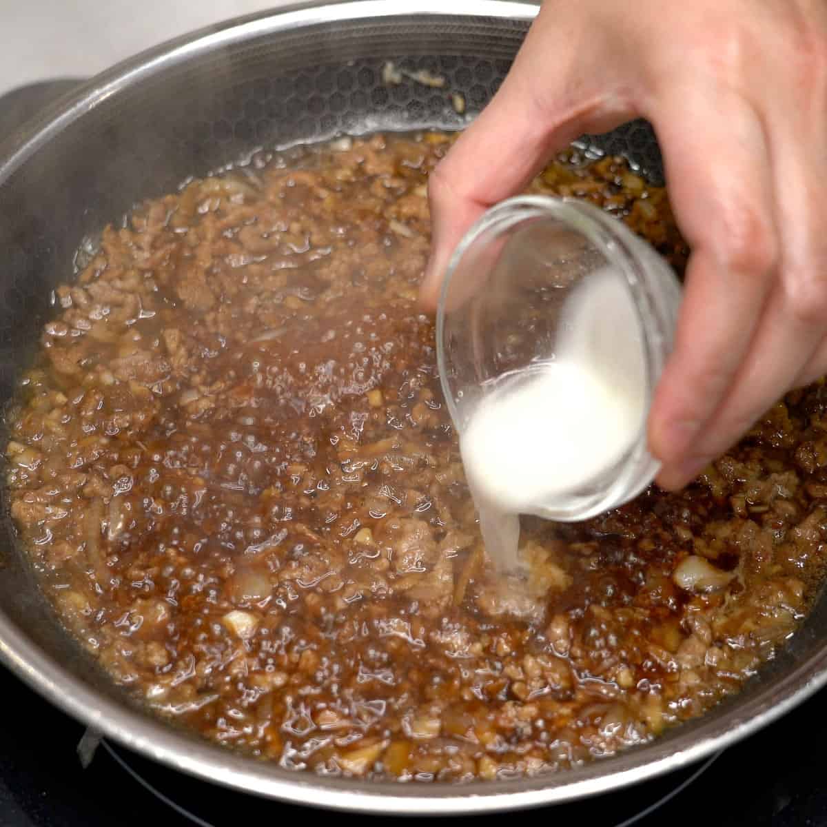 Adding cornstarch slurry to adobong talong with giniling.