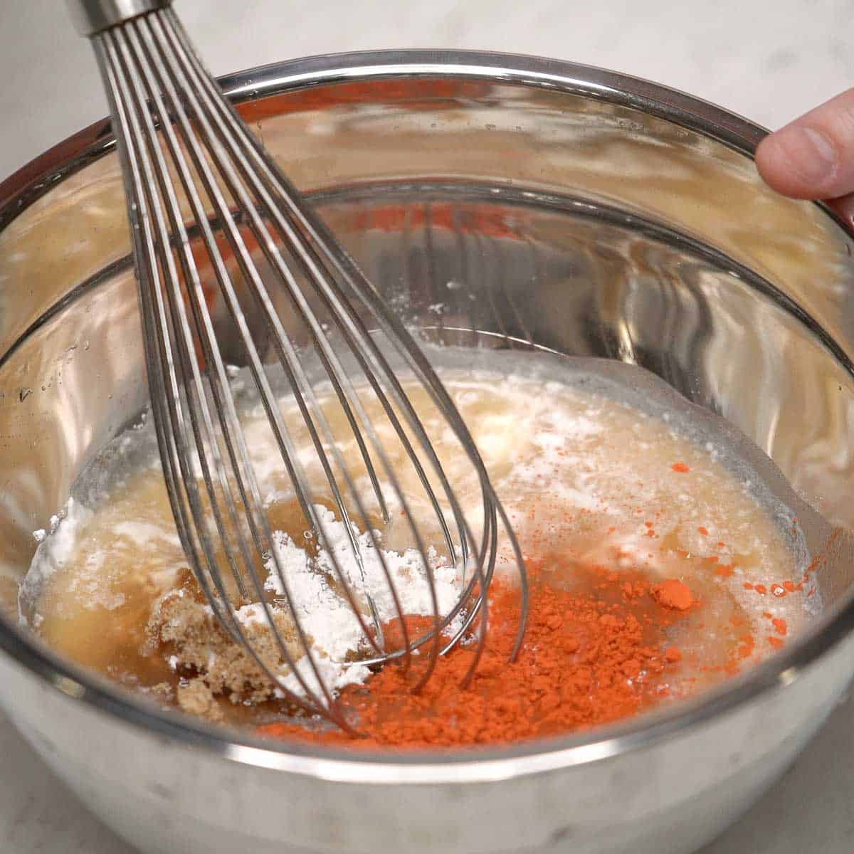 Mixing the kutsinta top layer in a bowl.