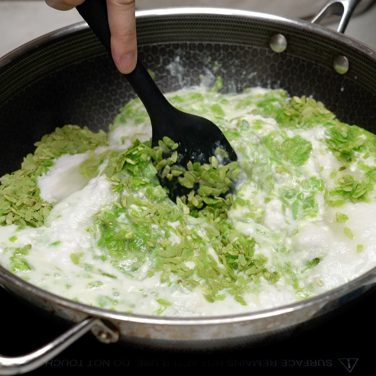 Mixing suman pinipig ingredients in a wok.