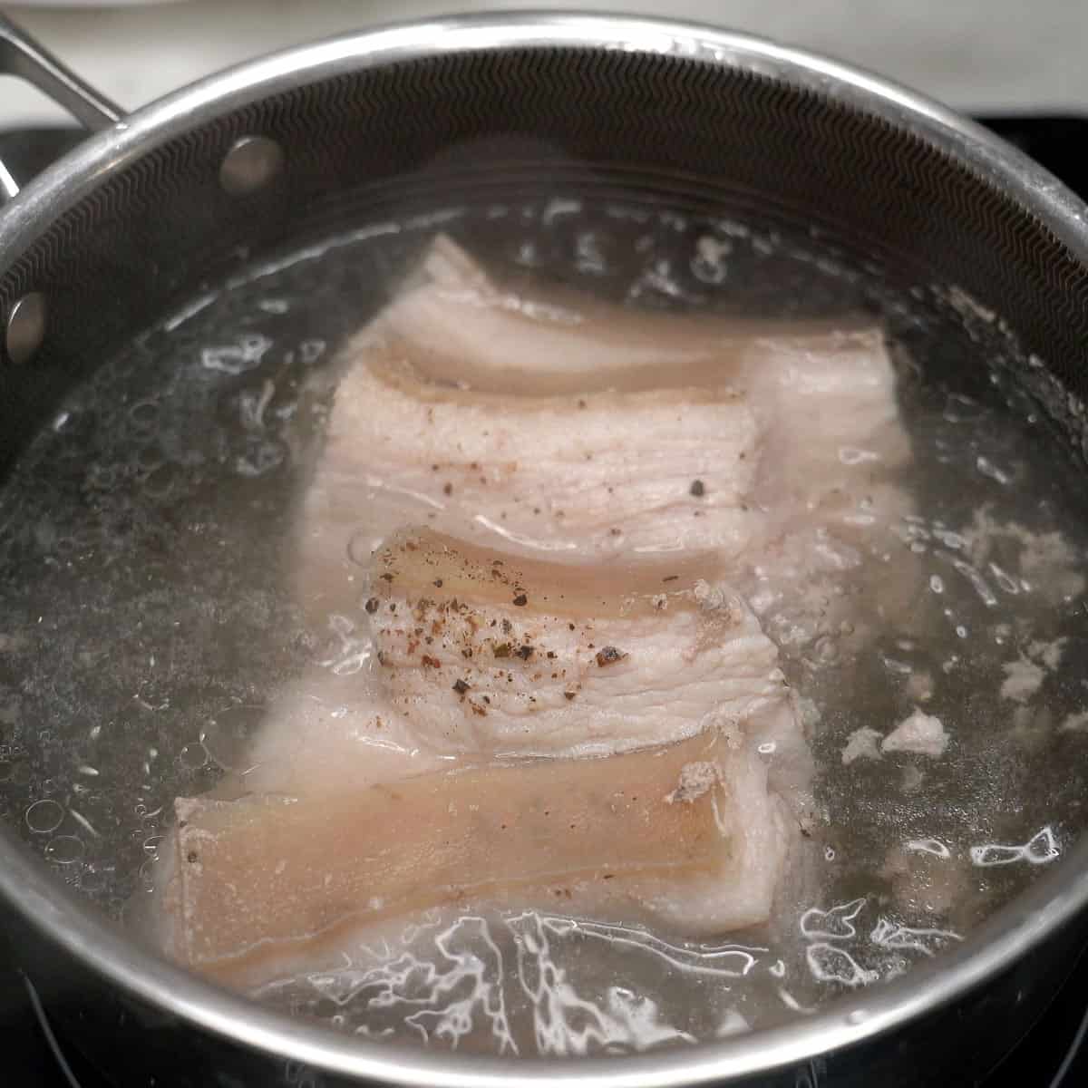 Boiling pork belly in a bowl.