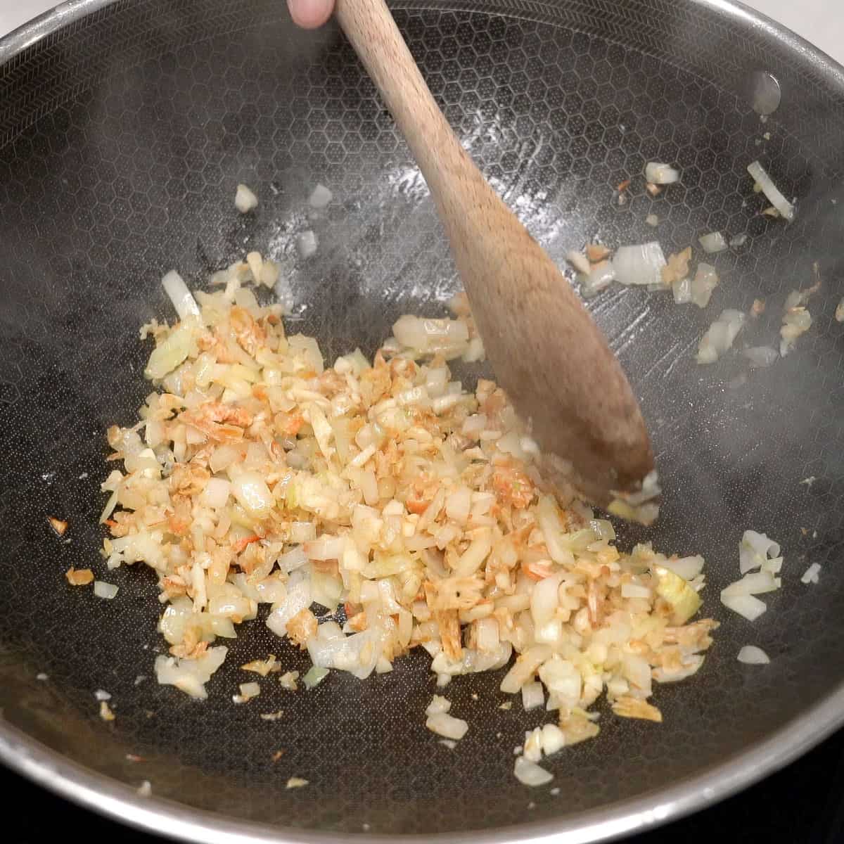 Sauteing aromatics and dried shrimp in a wok.