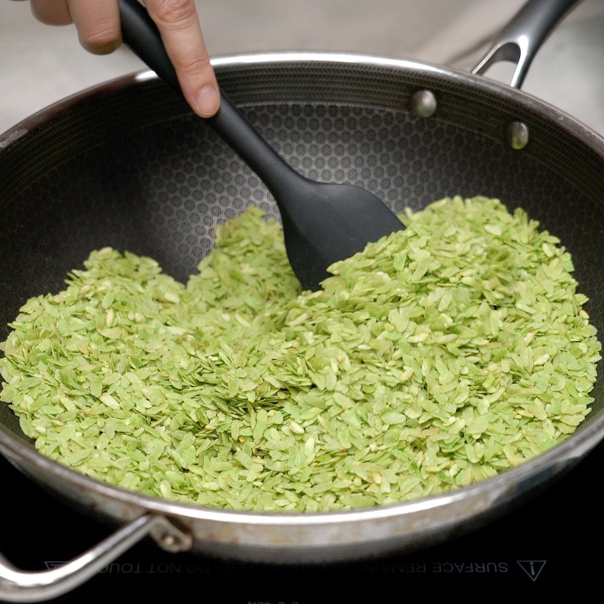 Toasting pinipig in a wok.