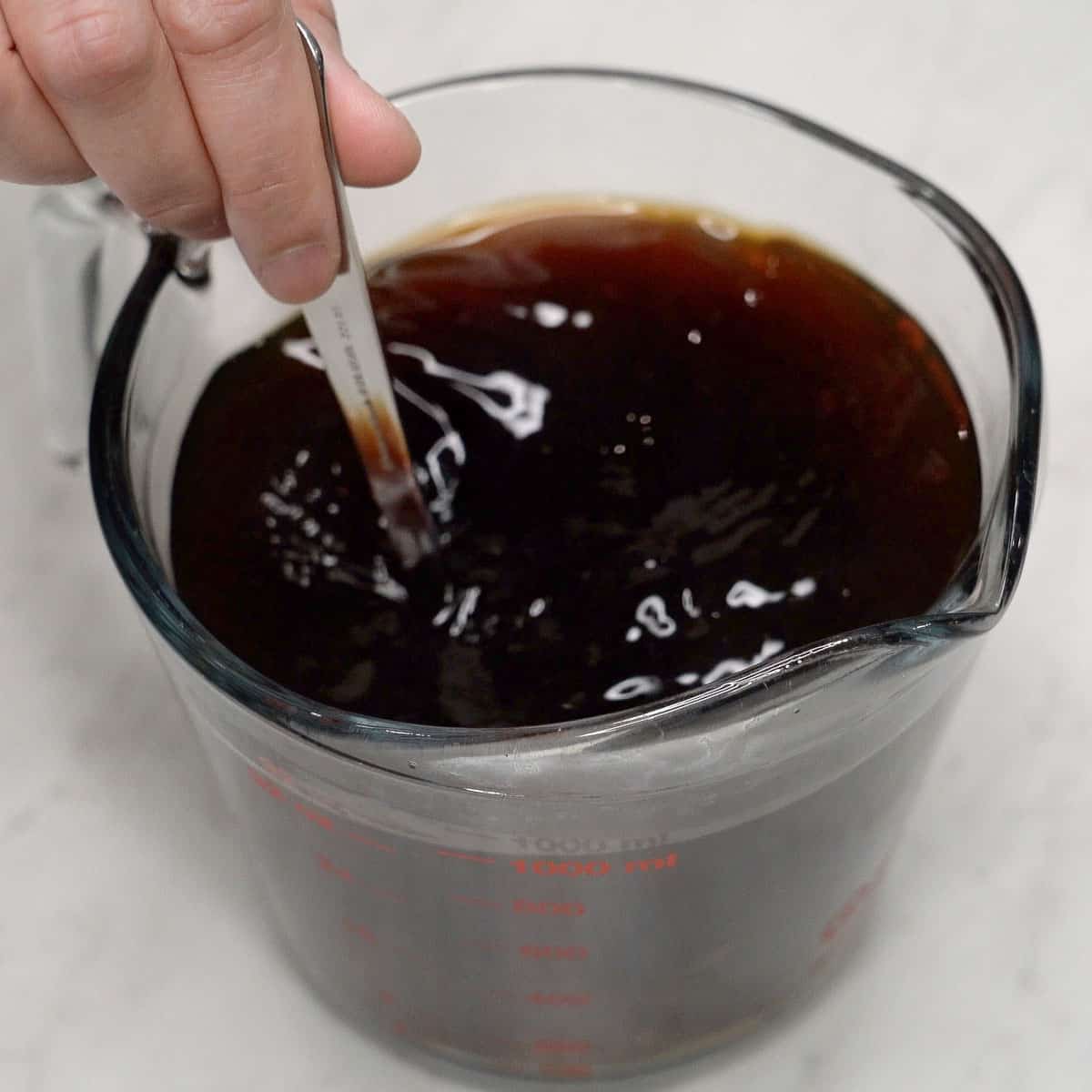 Mixing sauce for pancit bato in a cup.
