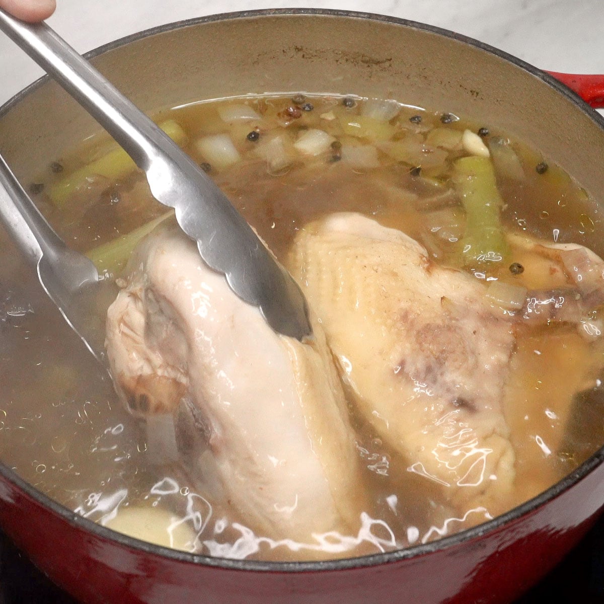 Removing the chicken from the pot.