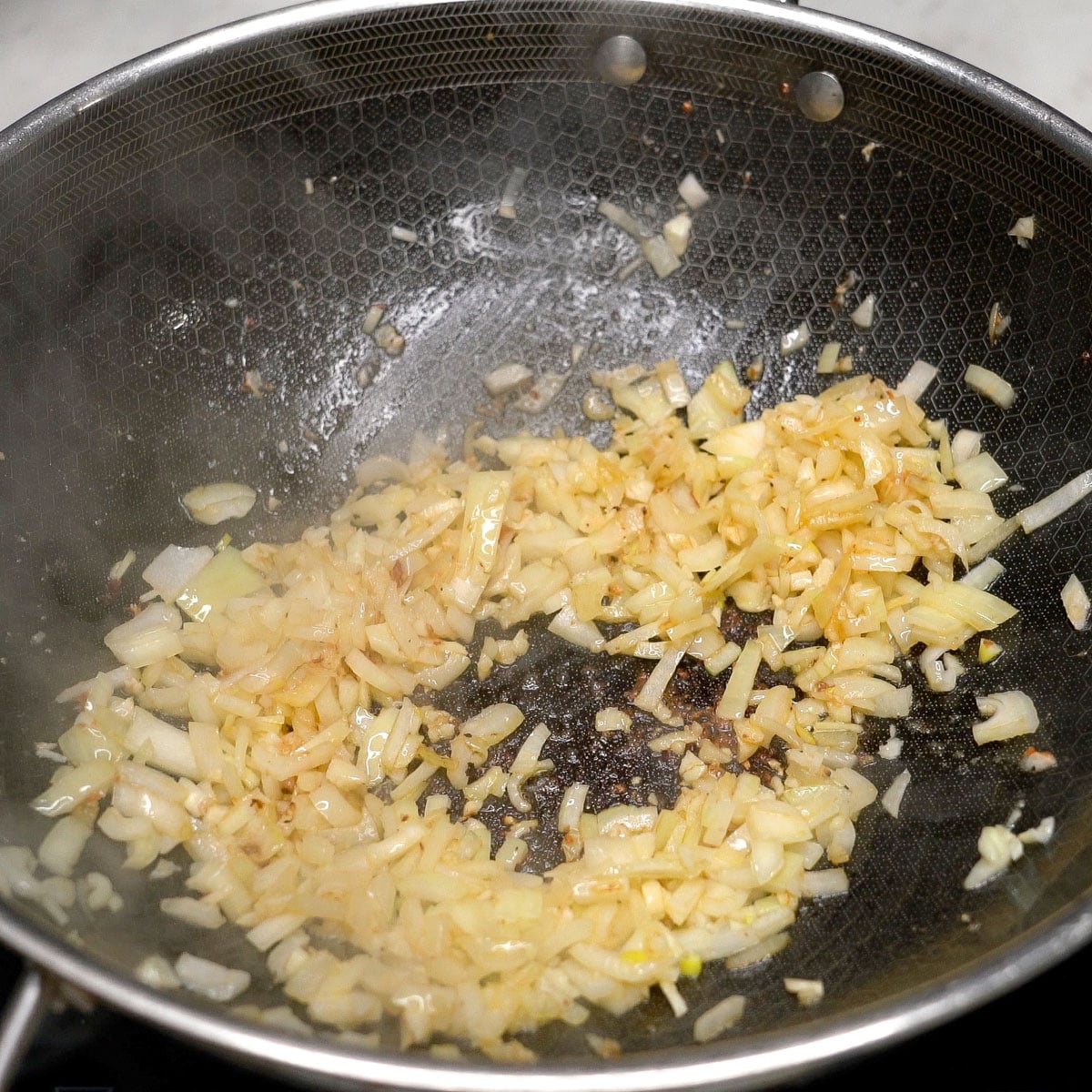 Sauteing aromatics in a wok.