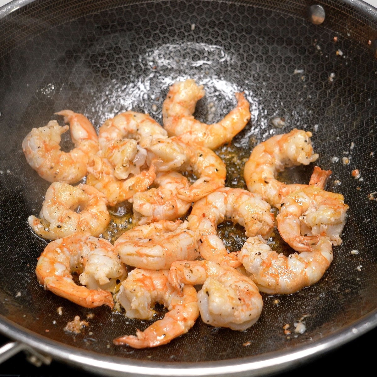 Searing the shrimp in a wok.