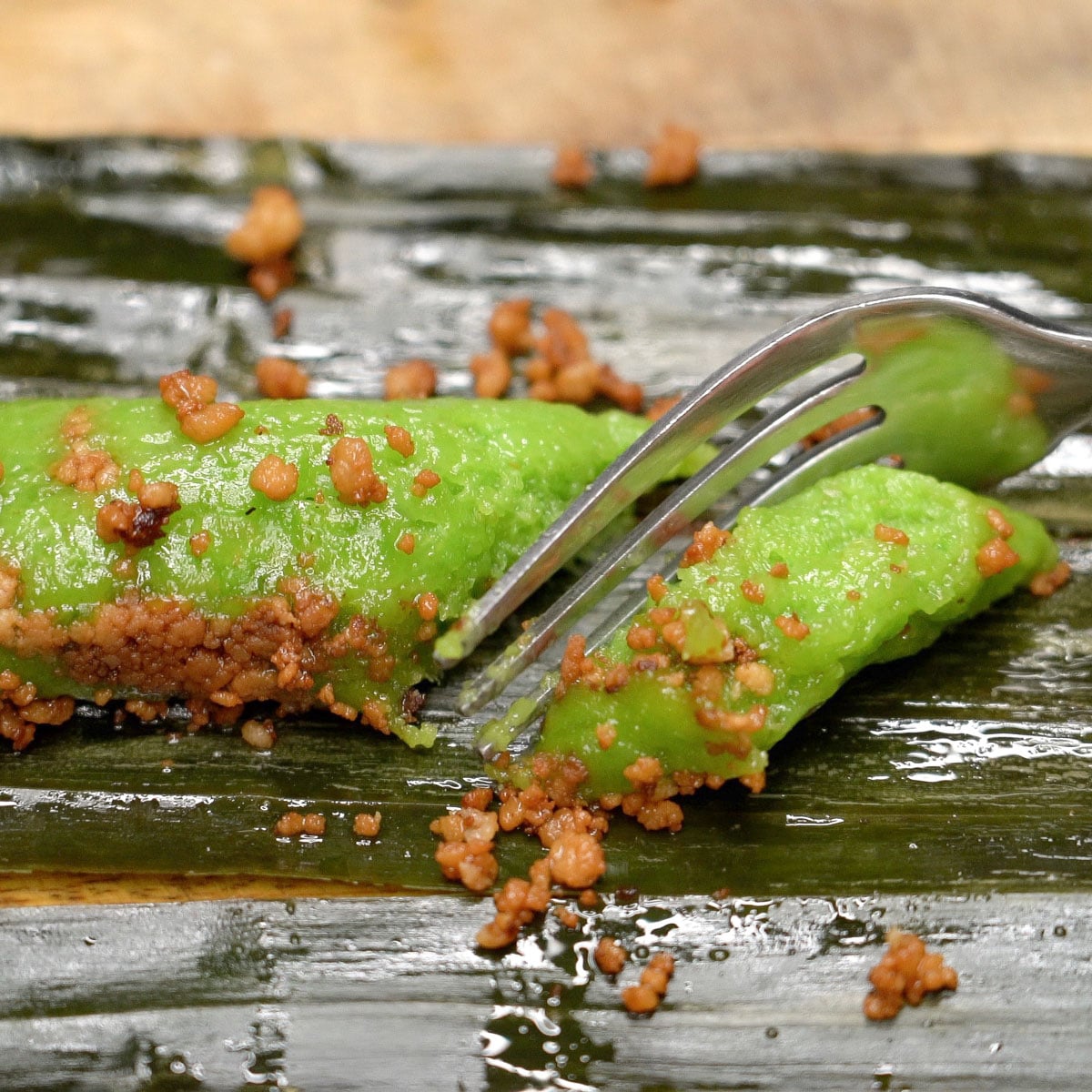 Cutting suman pinipig with latik using a fork.