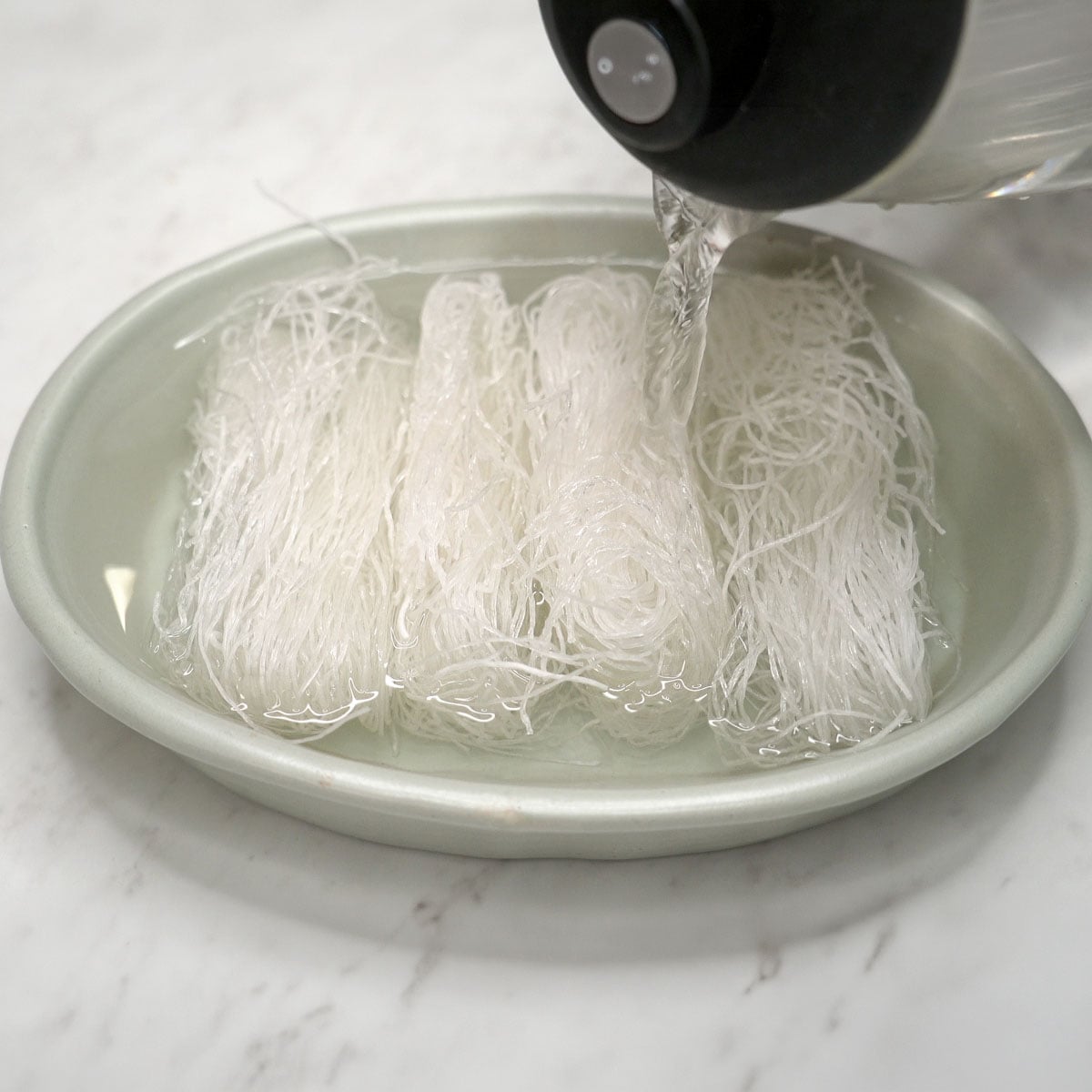 Pouring warm water over the sotanghon noodles.