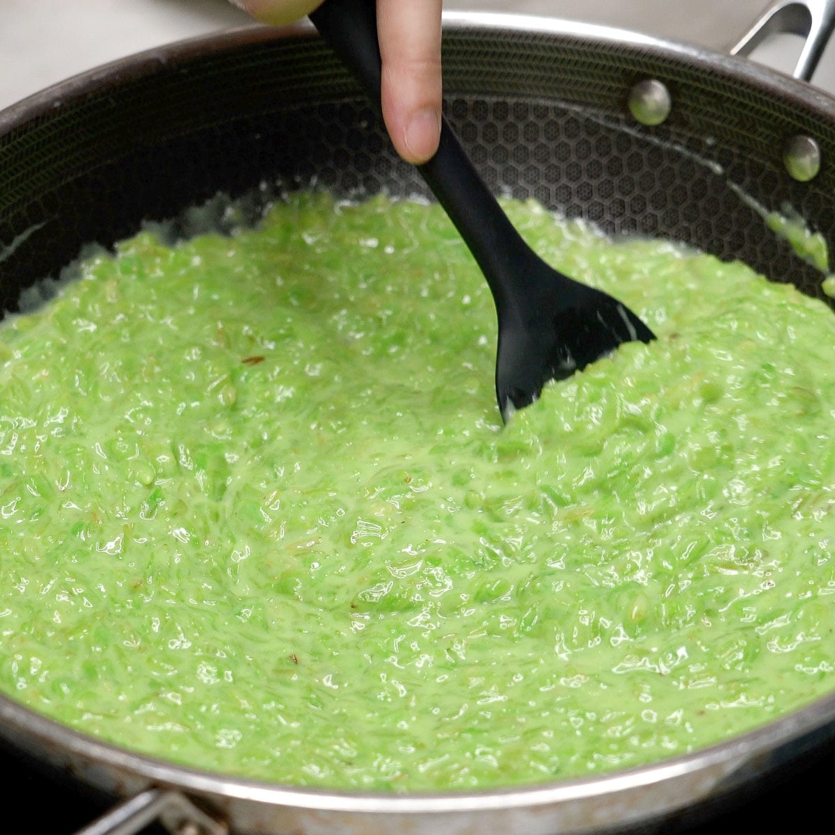 Mixing suman pinipig in a wok.
