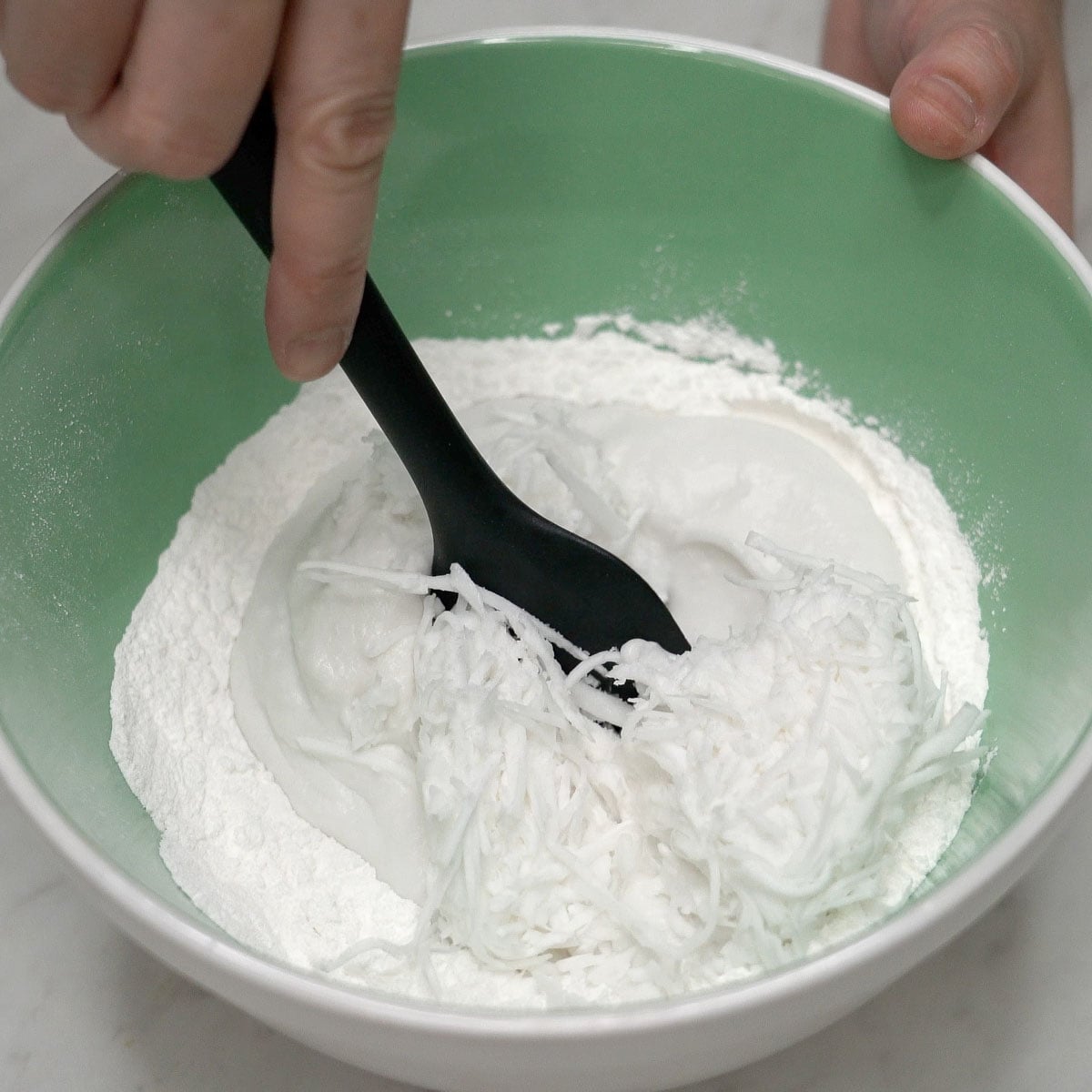 Combining tupig ingredients in a bowl.