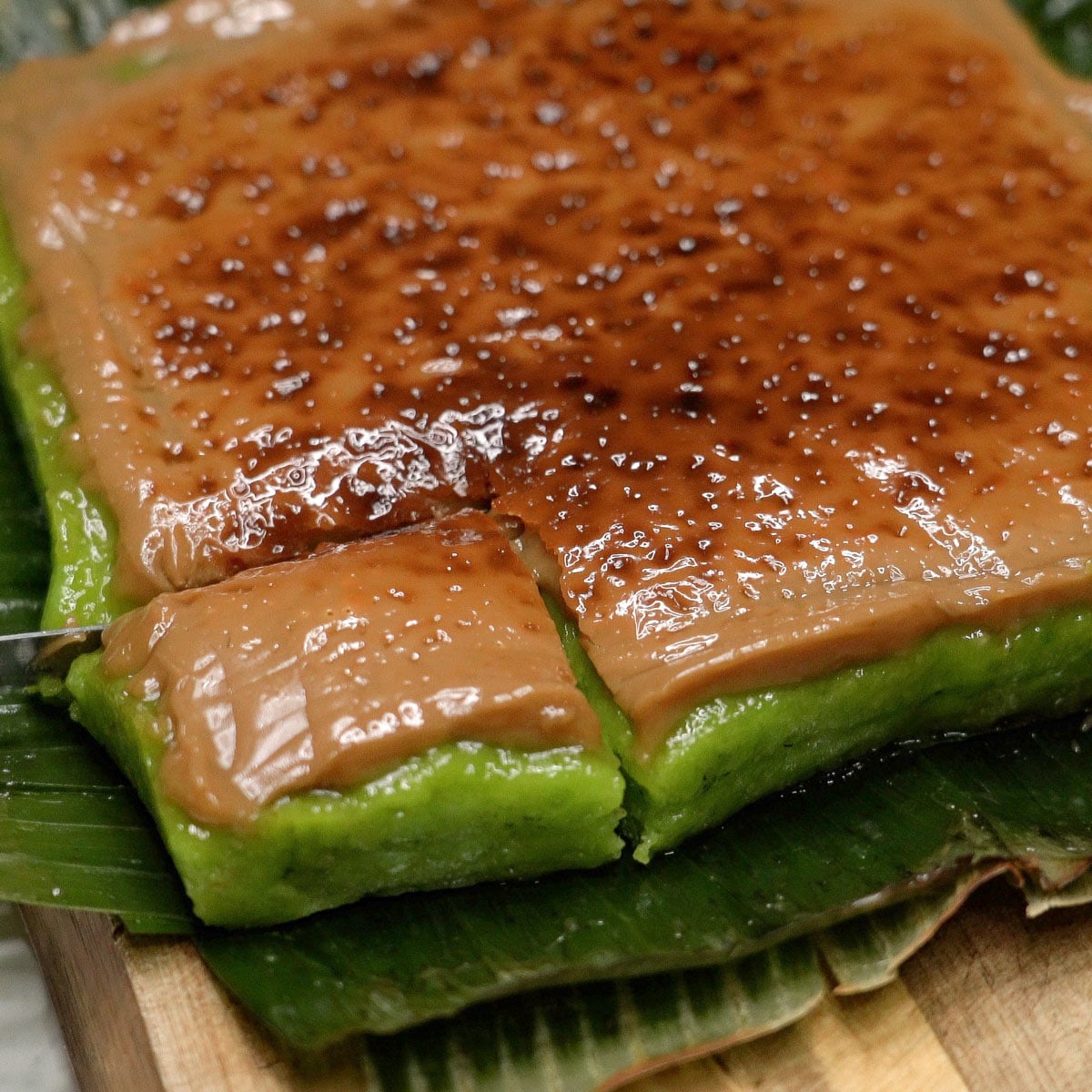 Slicing bibingkang pinipig on banana leaves.