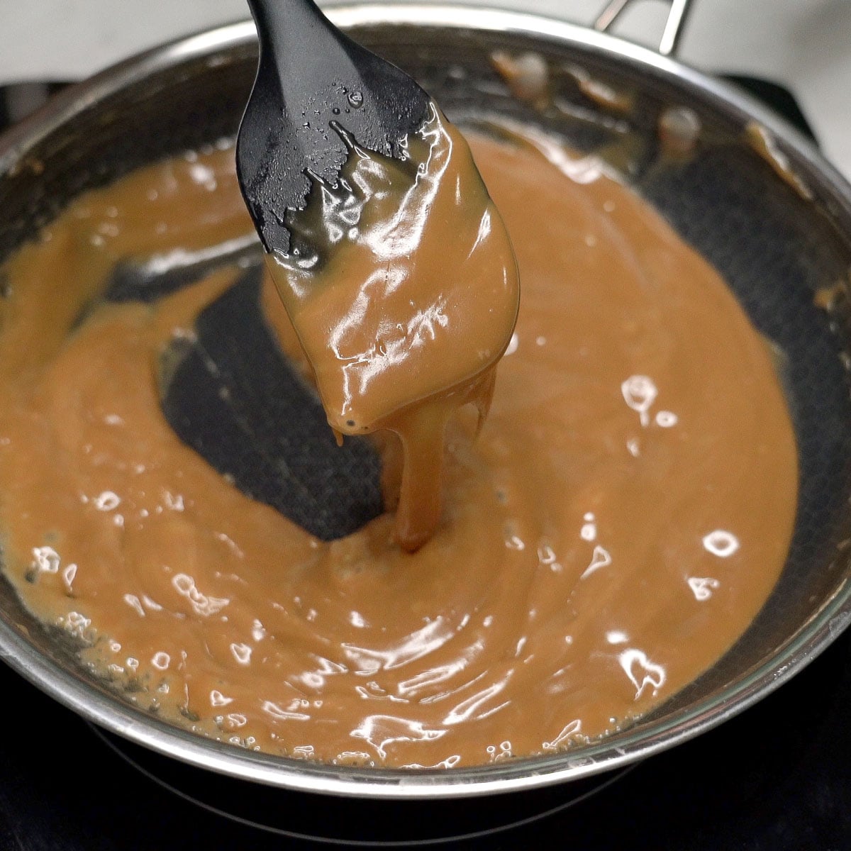 Thickened latik sauce on a spatula.