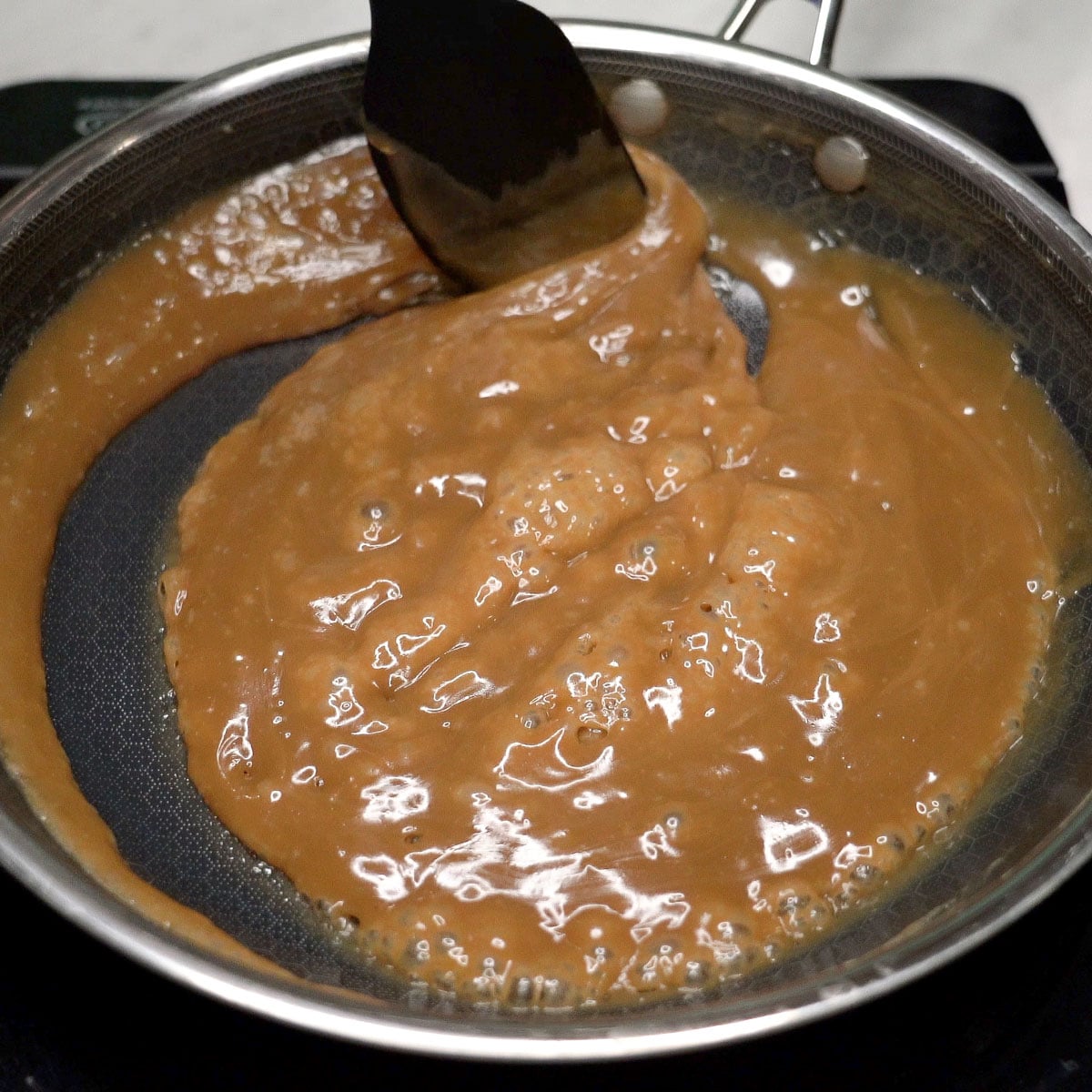 Mixing latik sauce in a pan.