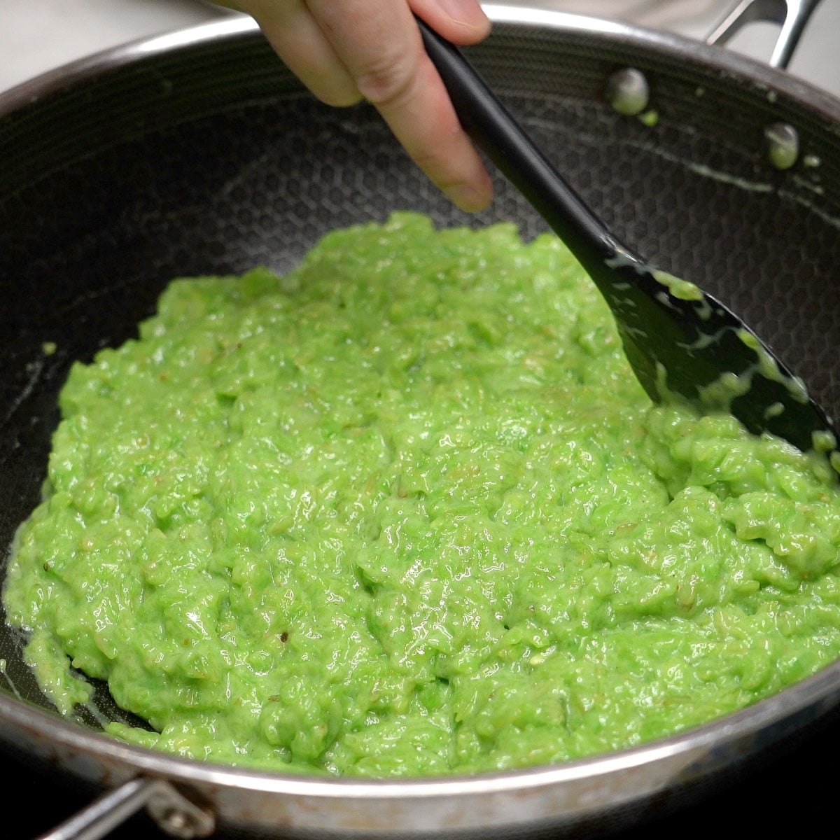 Mixing bibingkang pinipig mixture in  a wok.