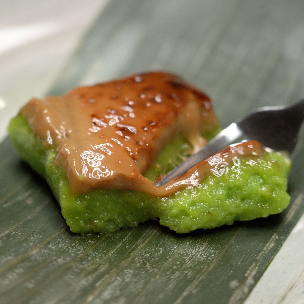 Cutting a slice of bibingkang pinipig with a fork.