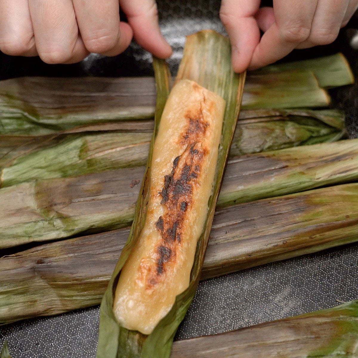 Tupig unwrapped from banana leaves with lightly charred top.