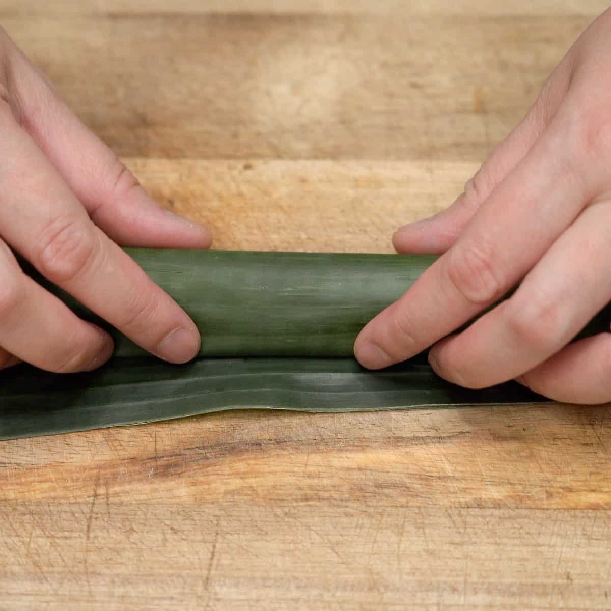 Rolled banana leaf with tupig mixture.